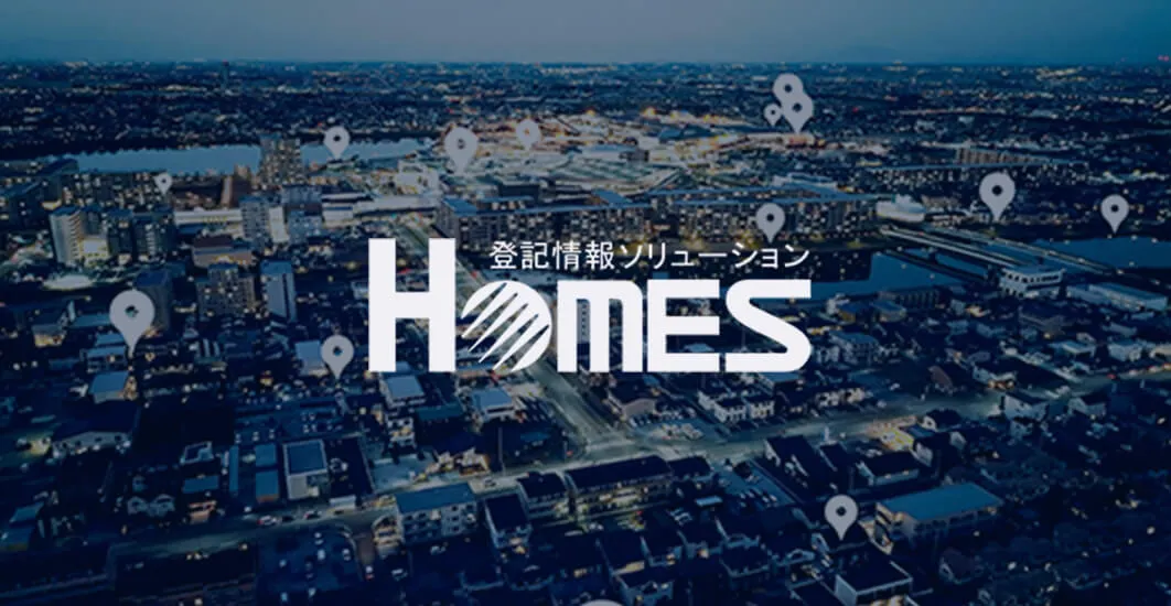 登記情報ソリューション HOMESのロゴと都市の風景