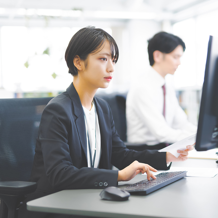 笑顔で説明を行う女性が、成果や考えを伝えているビジネスシーン