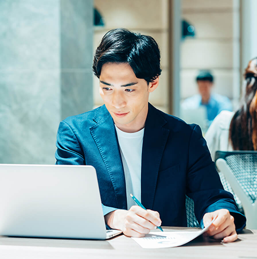 落ち着いた環境でノートパソコンに集中して作業するビジネスパーソン